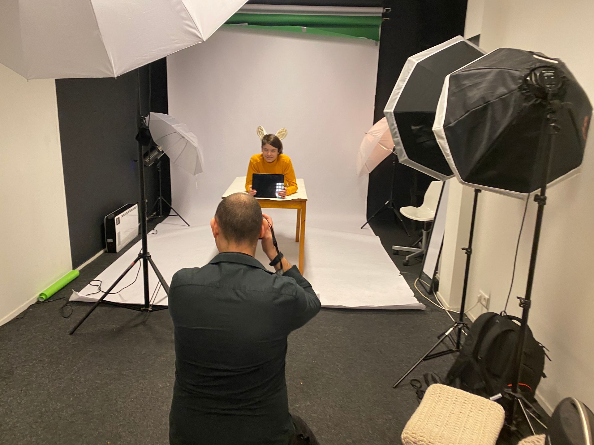 Een man maakt een foto van een vrouw in een fotostudio.