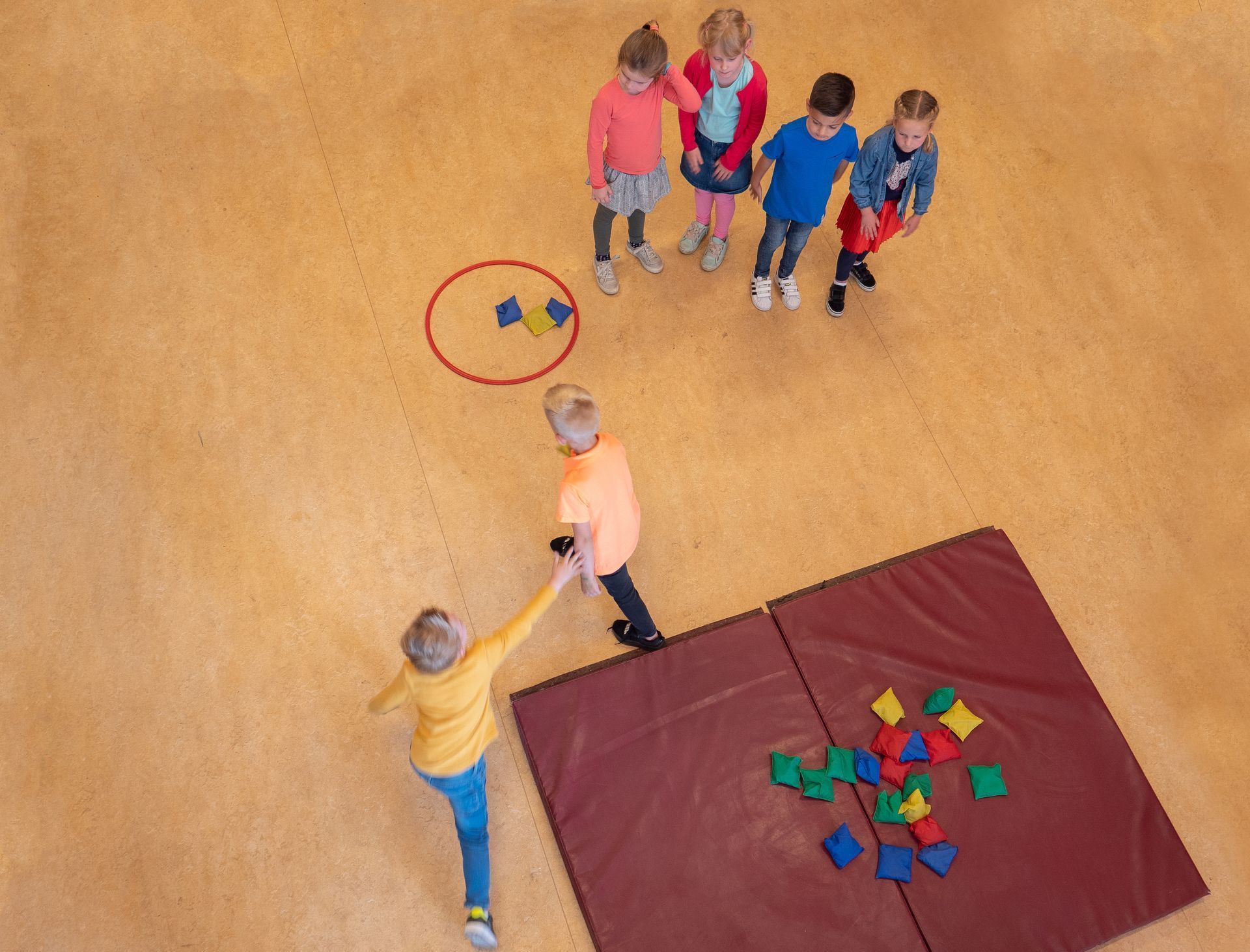 Een groep kinderen speelt een spel in een gymzaal.