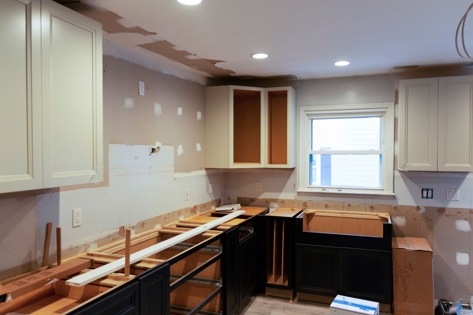 Kitchen remodel in progress: cabinets installed, drywall patches, awaiting countertops and backsplash.