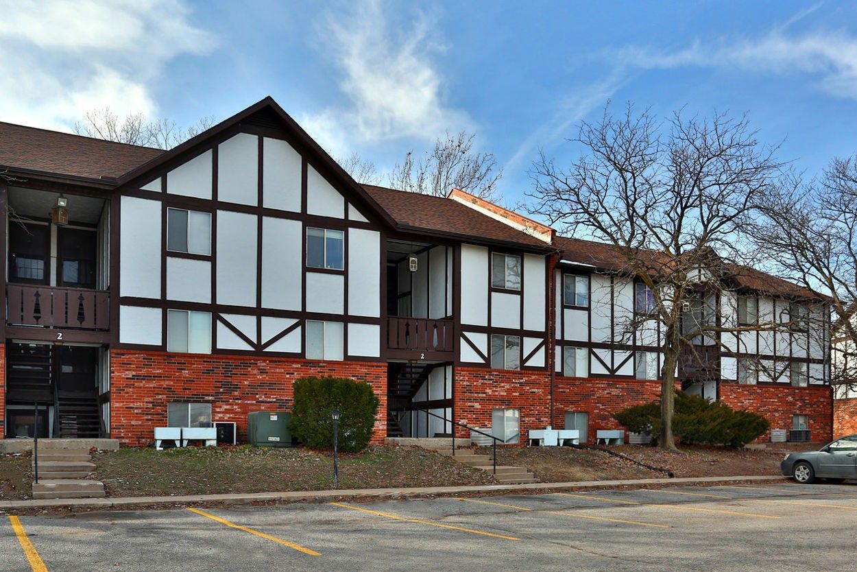 A large apartment building with a car parked in front of it