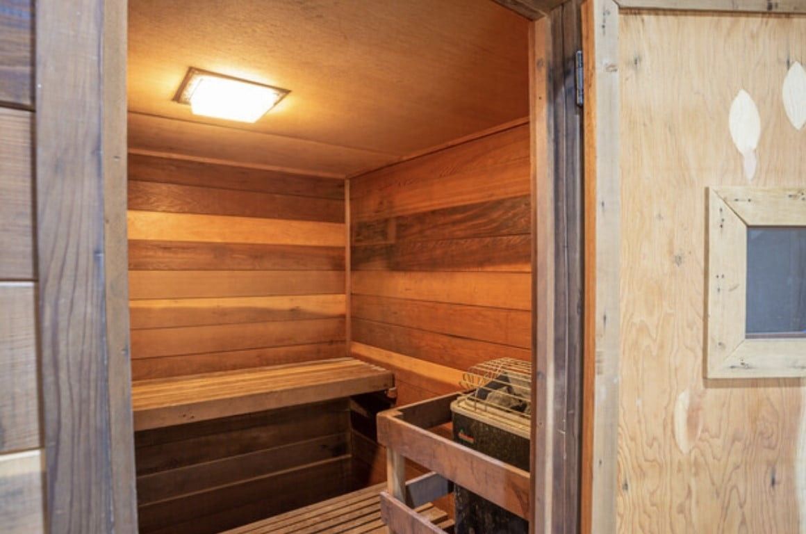 A wooden sauna with a bench and a window.