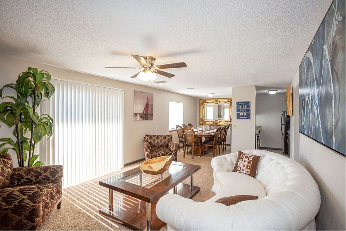 A living room filled with furniture and a ceiling fan.