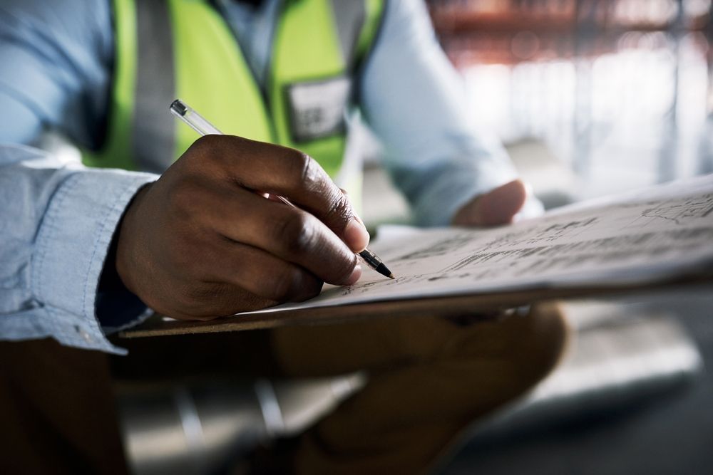 A man is writing on a clipboard with a pen.