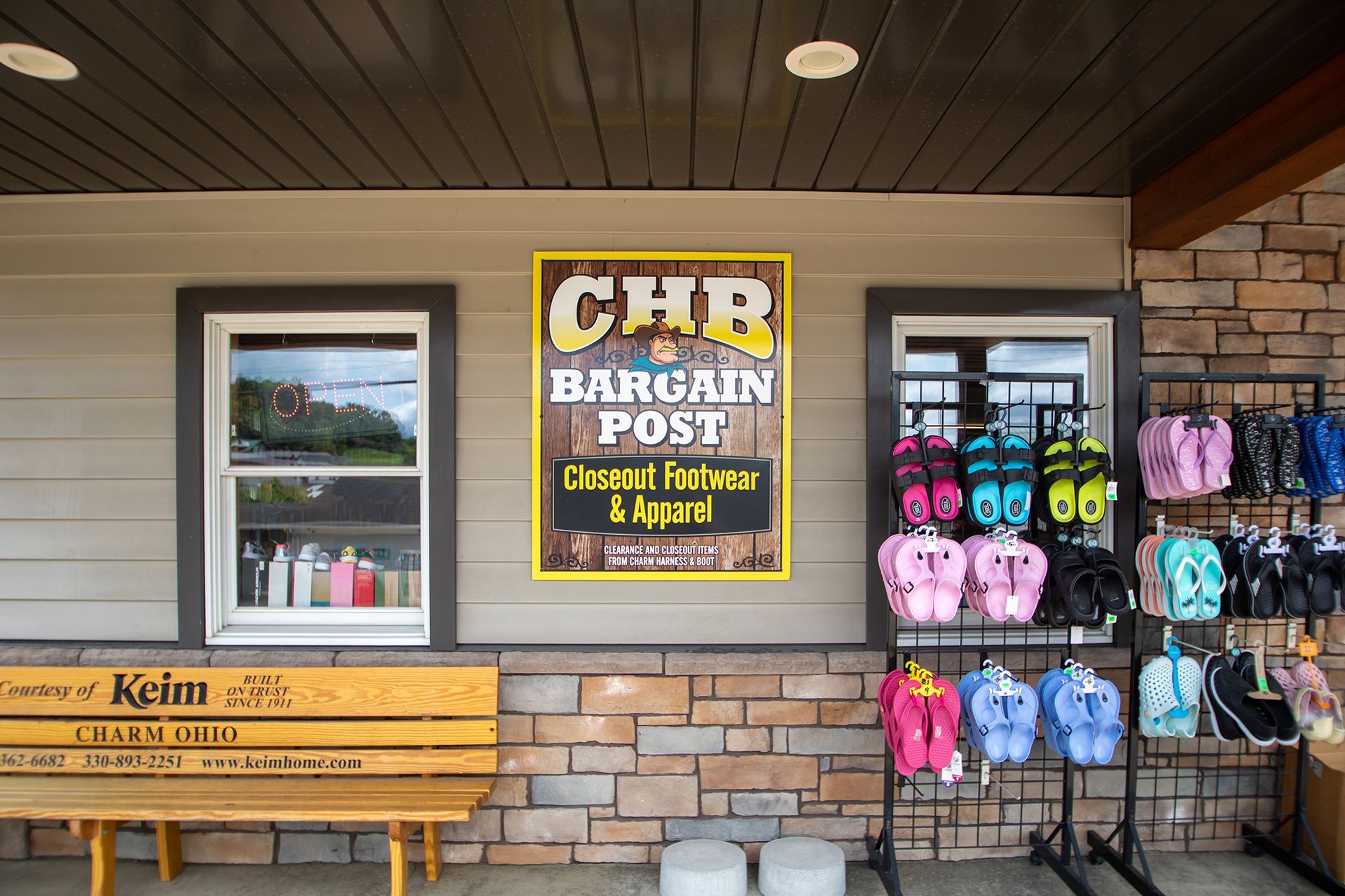 CHB Bargin Post storefront with bench, window, and colorful flip-flops and sandals on display