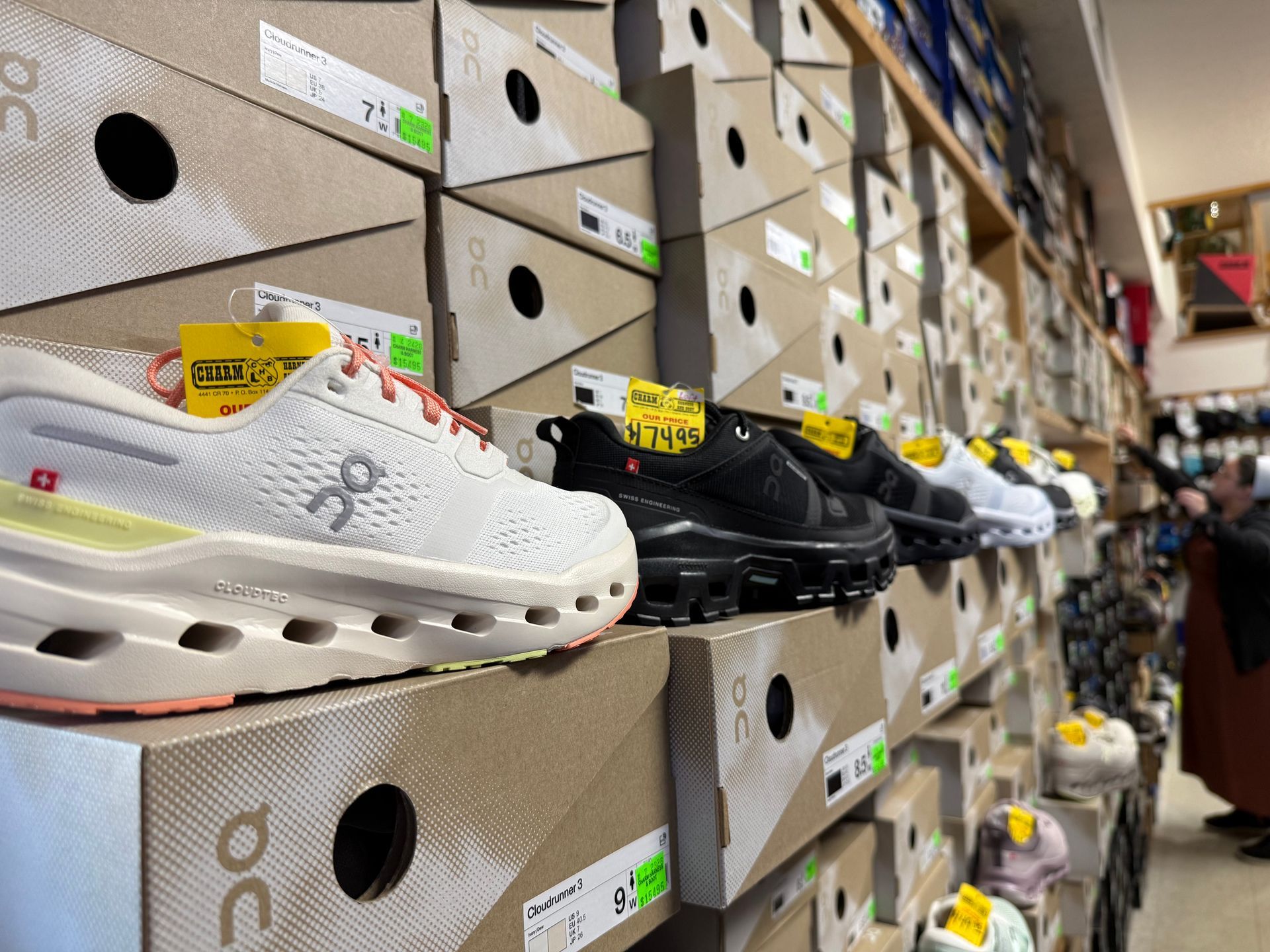 Rows of shoes displayed on store shelves, with white and black pairs in the foreground.