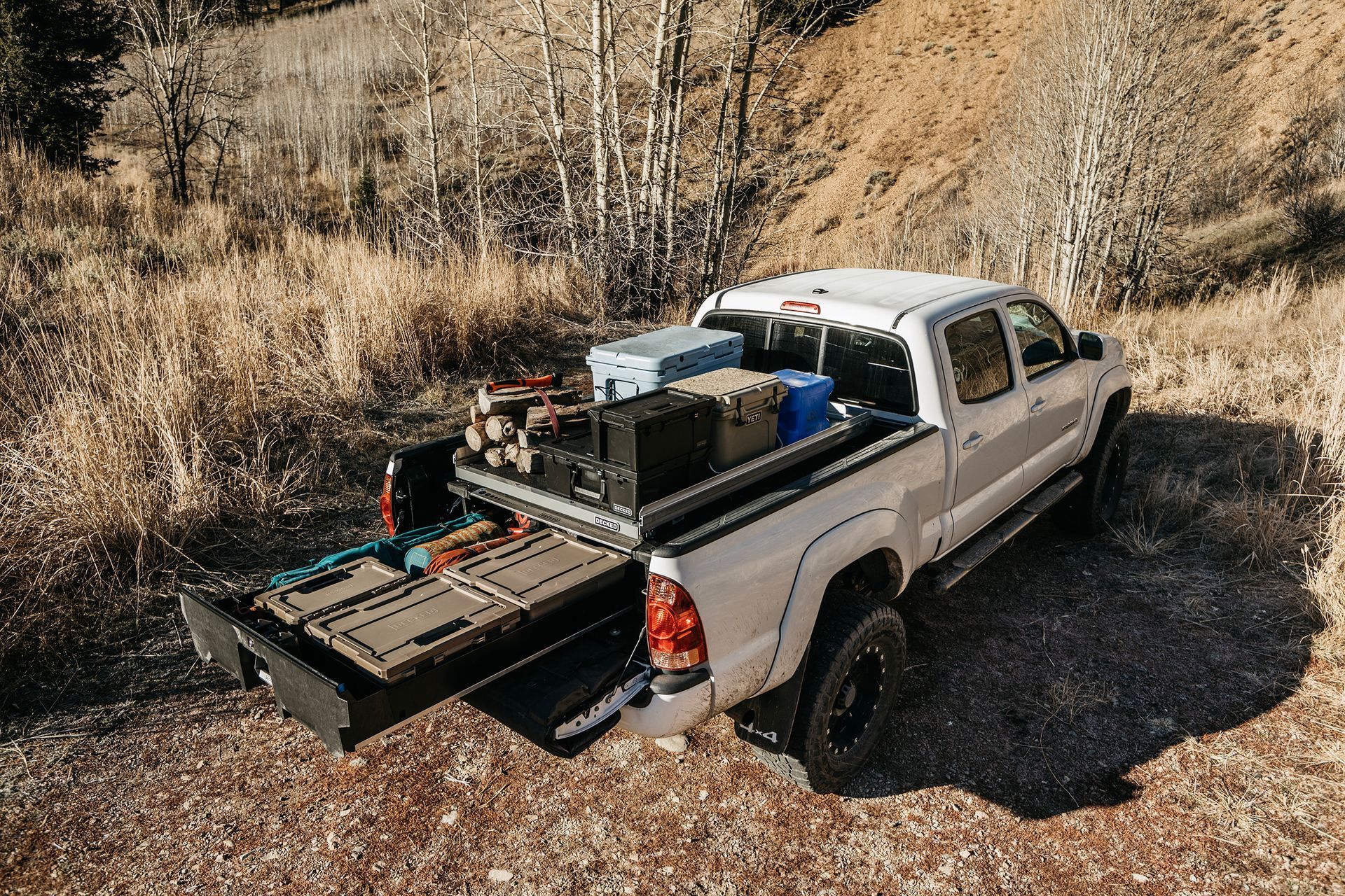 A white truck is parked on top of a dirt hill.