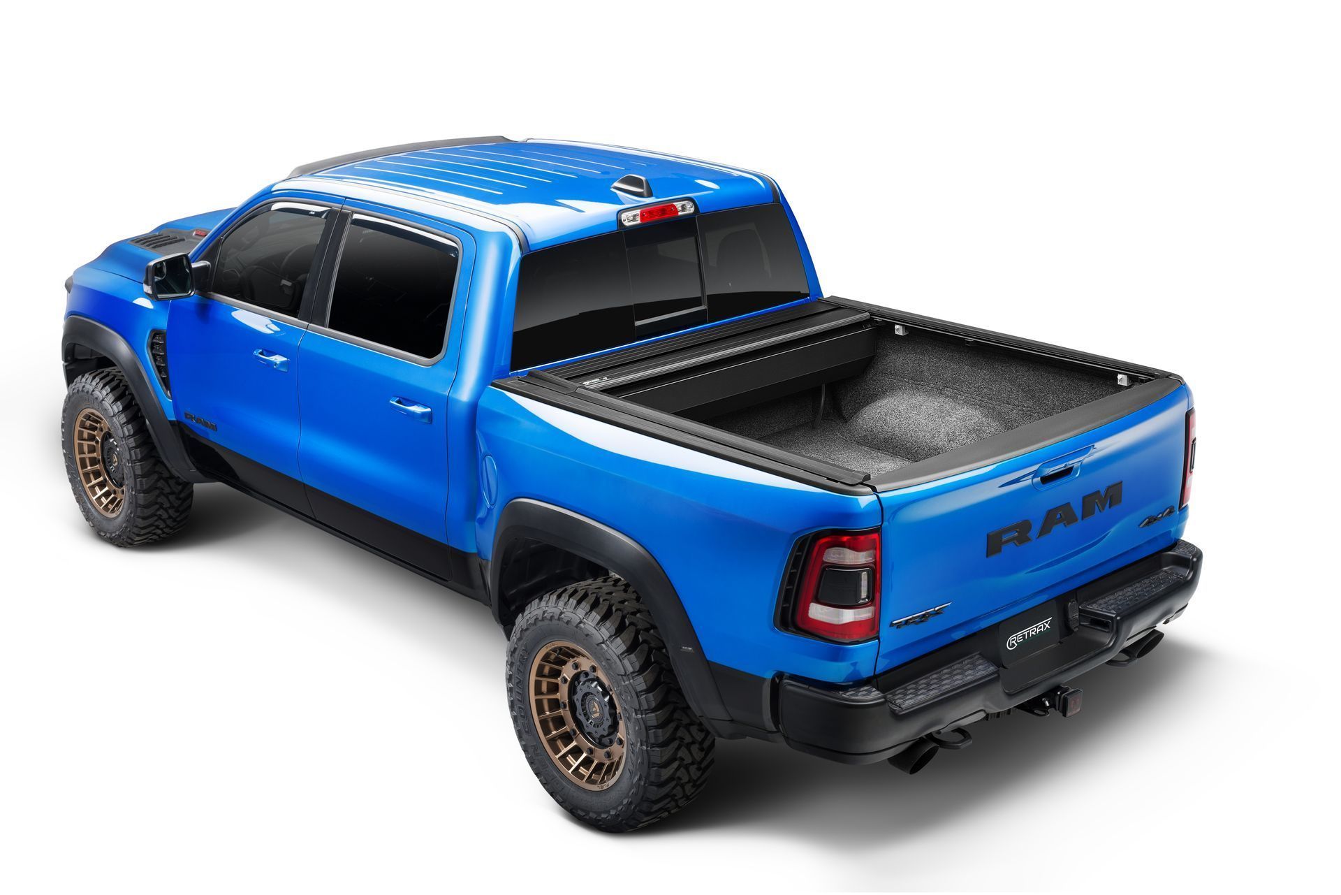 A blue ram truck with a black bed cover on a white background.