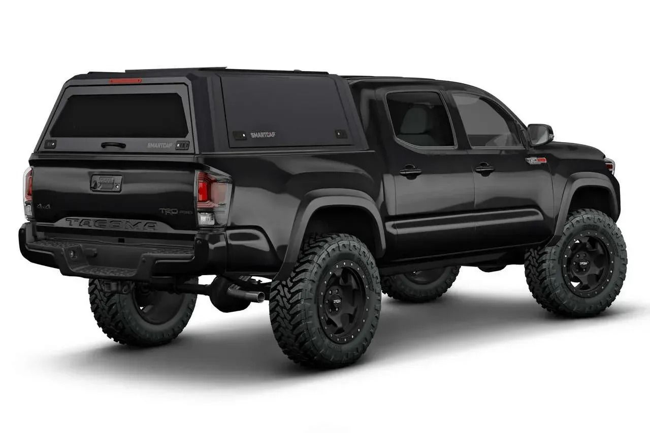 A black truck with a canopy on top of it on a white background.