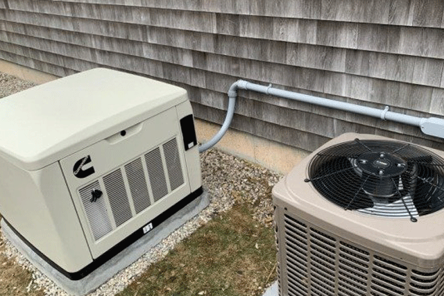 MJS Electrical Services - A generator is sitting next to an air conditioner on the side of a house.