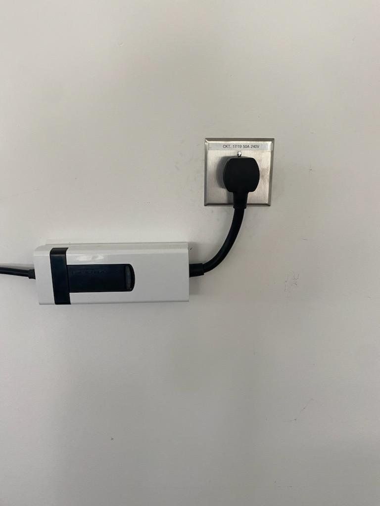 MJS Electrical Services - A power cord is plugged into a wall outlet.