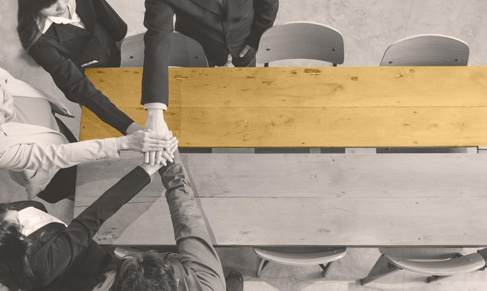 Business professionals joining hands together in teamwork