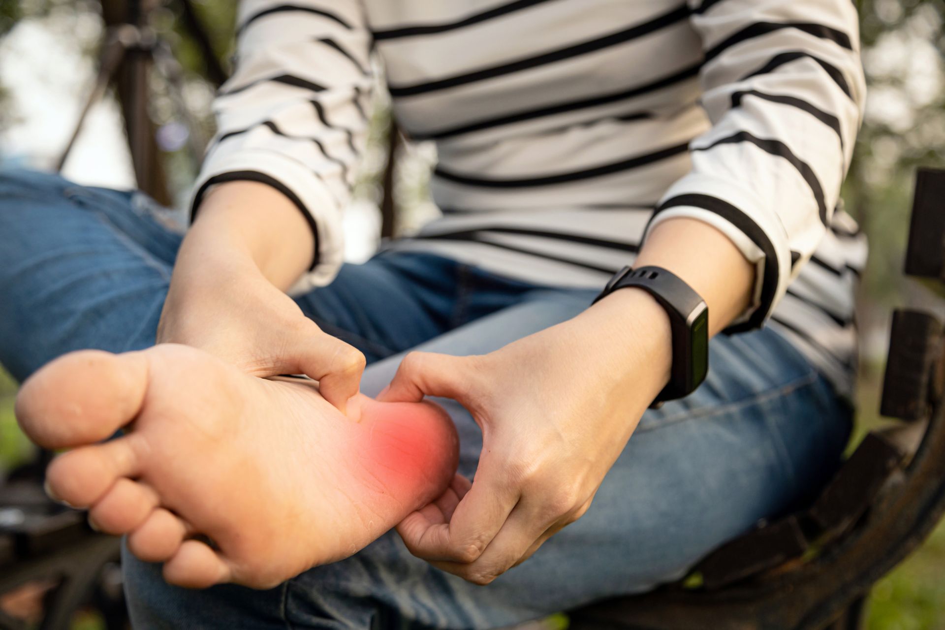 Person holding foot with red highlight indicating pain.