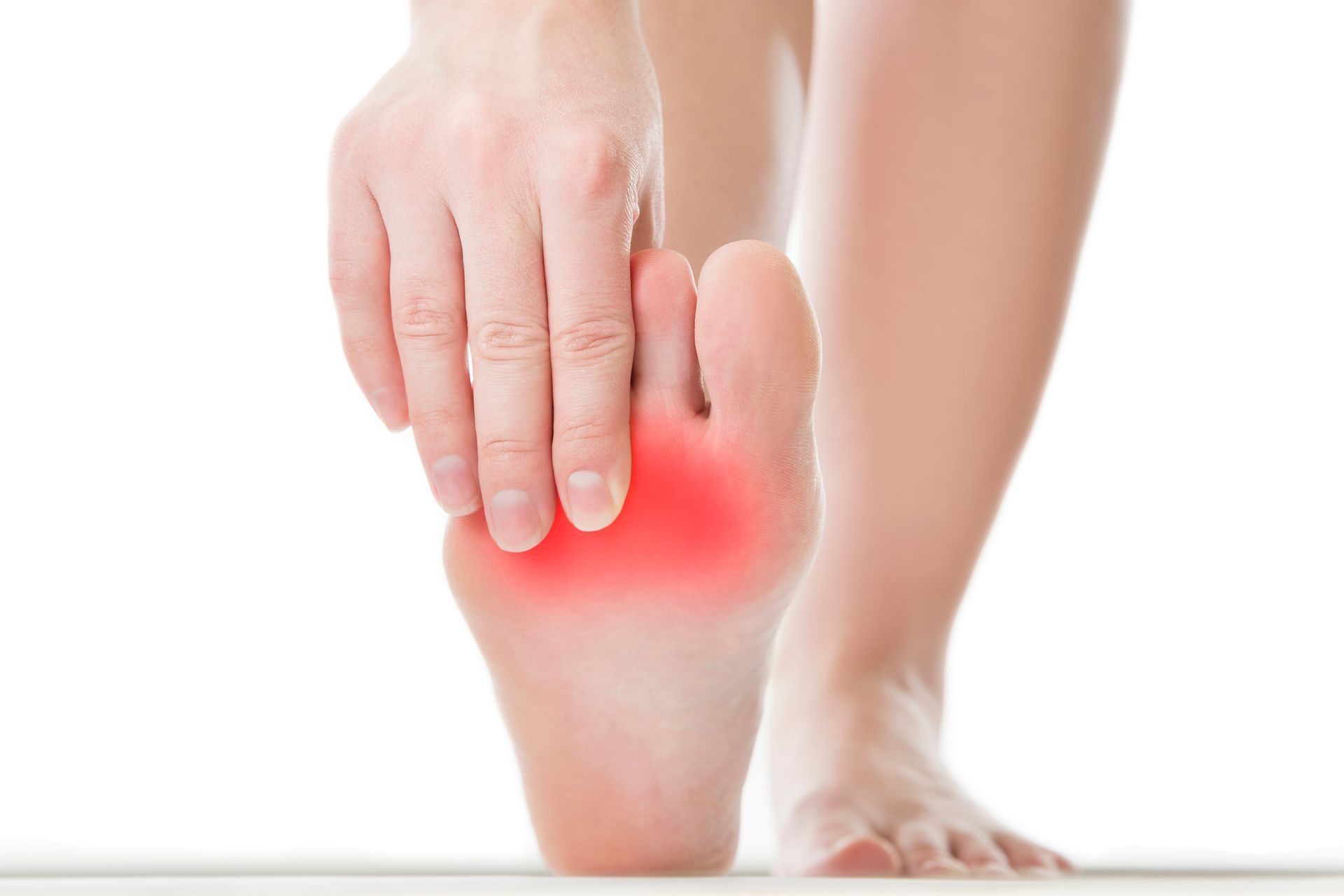 Foot with a red area on the sole, hand touching the painful spot, indicating foot pain.