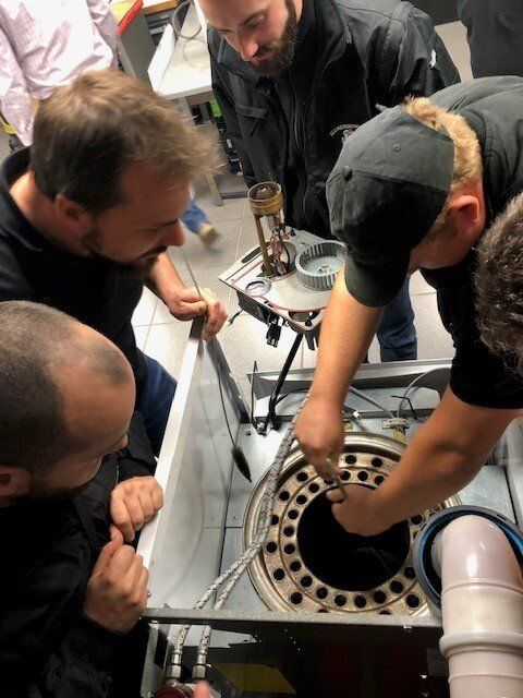 Un groupe d'hommes travaille sur une machine.