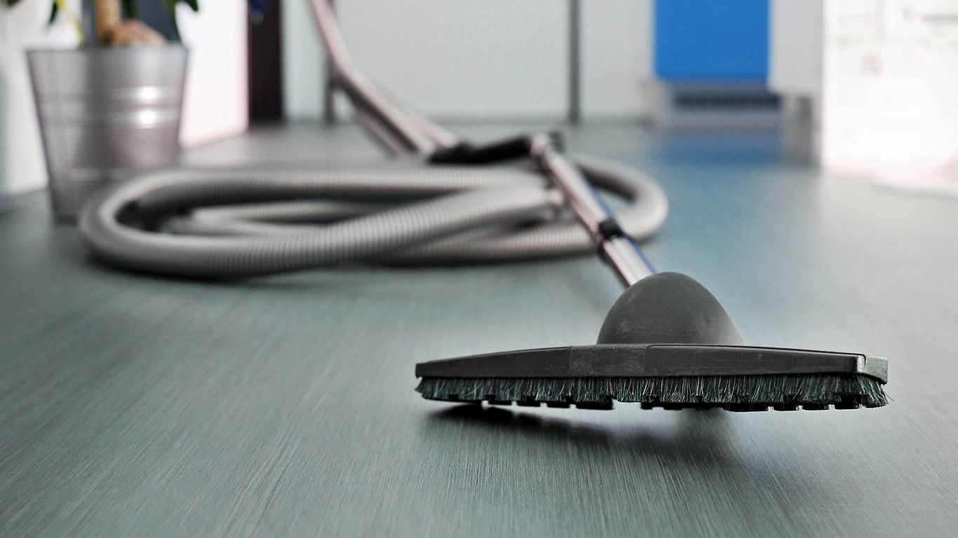 Un aspirateur est posé sur un plancher en bois.