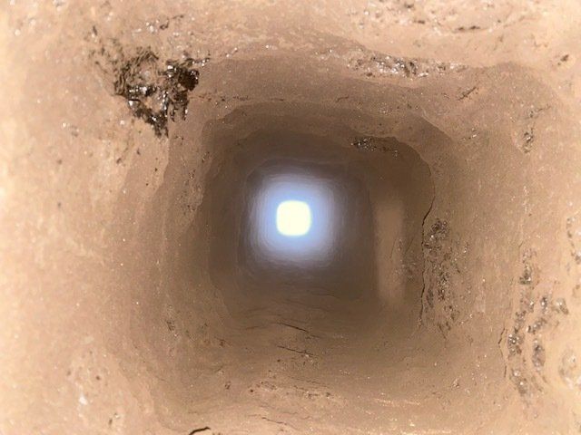 Un trou dans le sol d'où sort une lumière.
