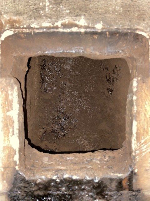 Un trou carré dans un mur de briques avec un trou au milieu