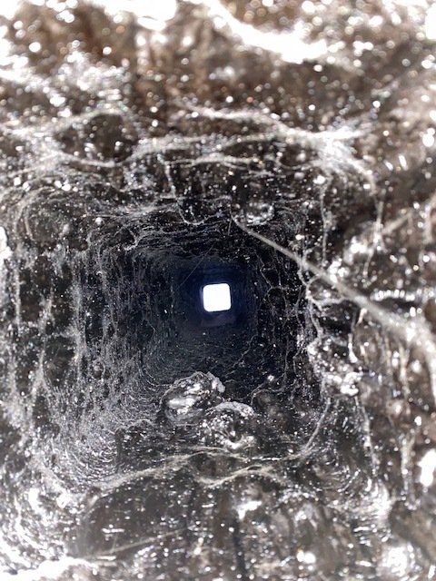 Un gros plan d'un trou dans le sol avec une lumière qui en sort.