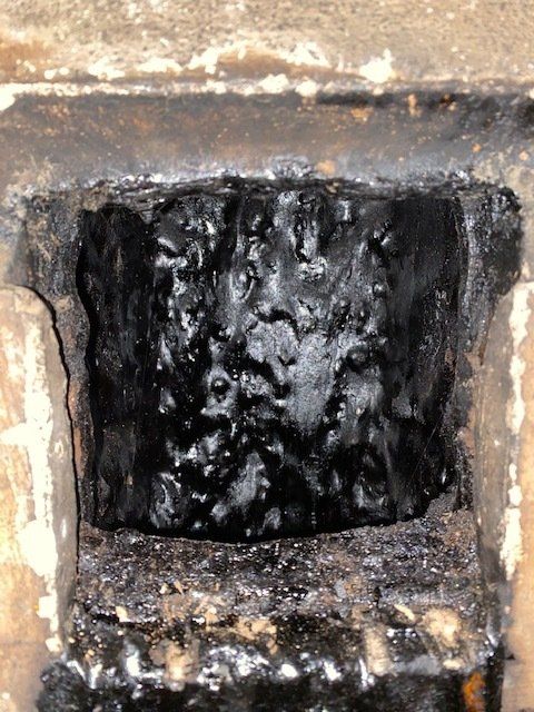 Un gros plan d'un trou dans un mur d'où sort une substance noire
