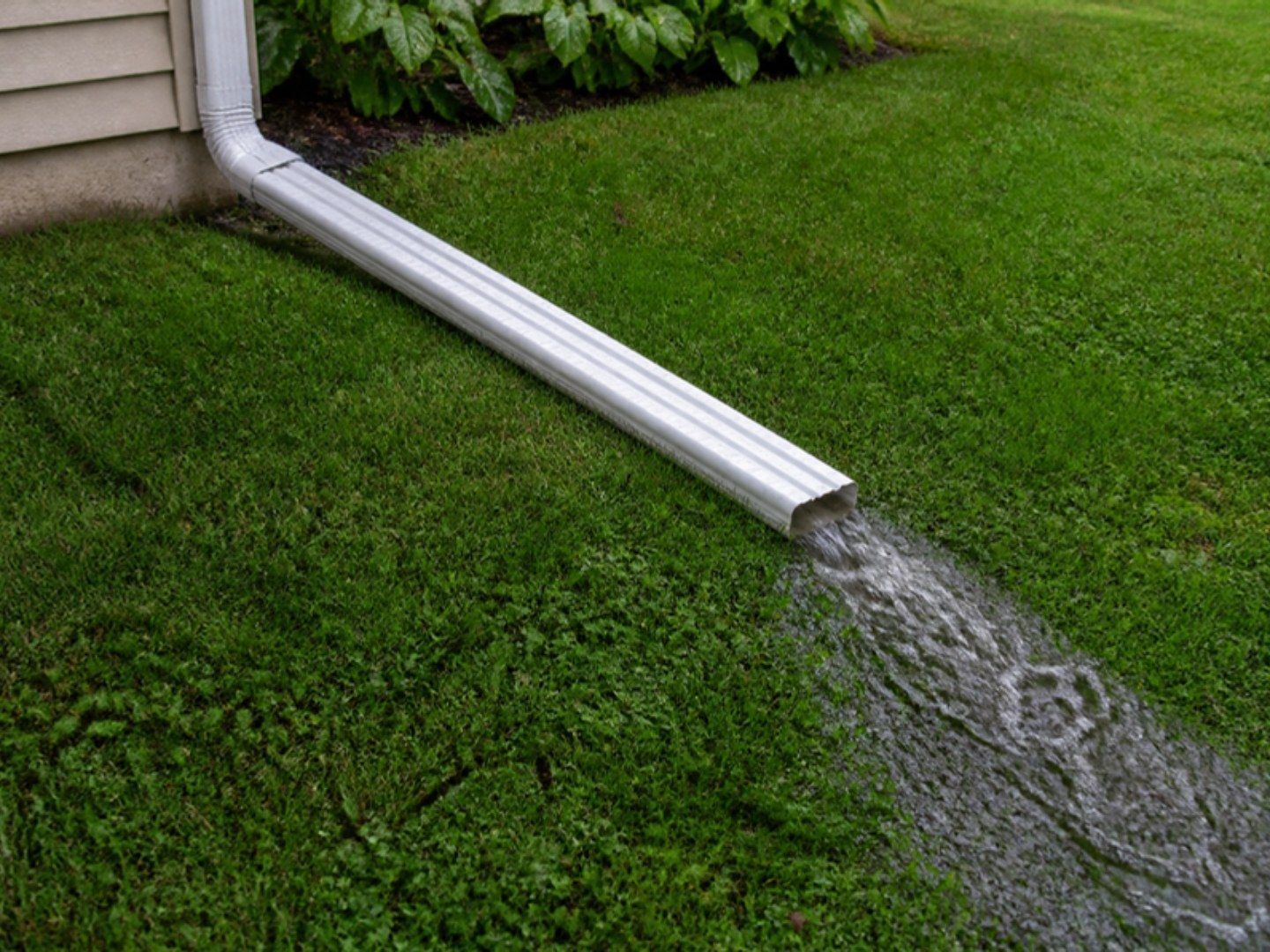 Downspout extension carrying rain water across the lawn away from the foundation