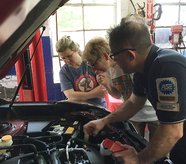 Our team with customers discussing what's under the hood of a car in Melrose, MA | Certified Automotive Solutions