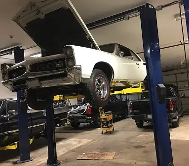 White car in garage with hood up in Melrose, MA | Certified Automotive Solutions