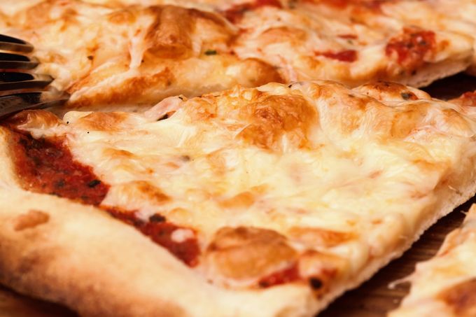 Primo piano di fette di pizza al salame piccante e formaggio su un piatto