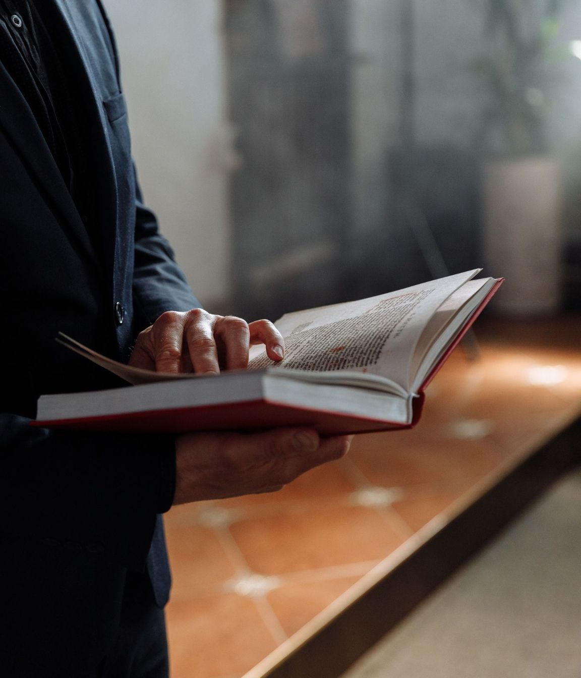 A man in a suit is reading the Bible