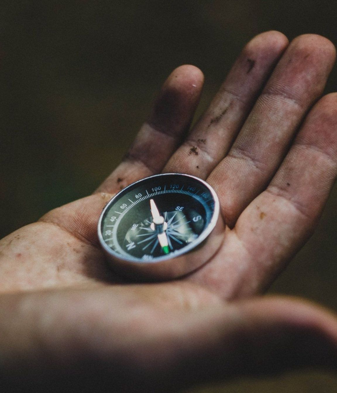 A person is holding a compass in their left hand