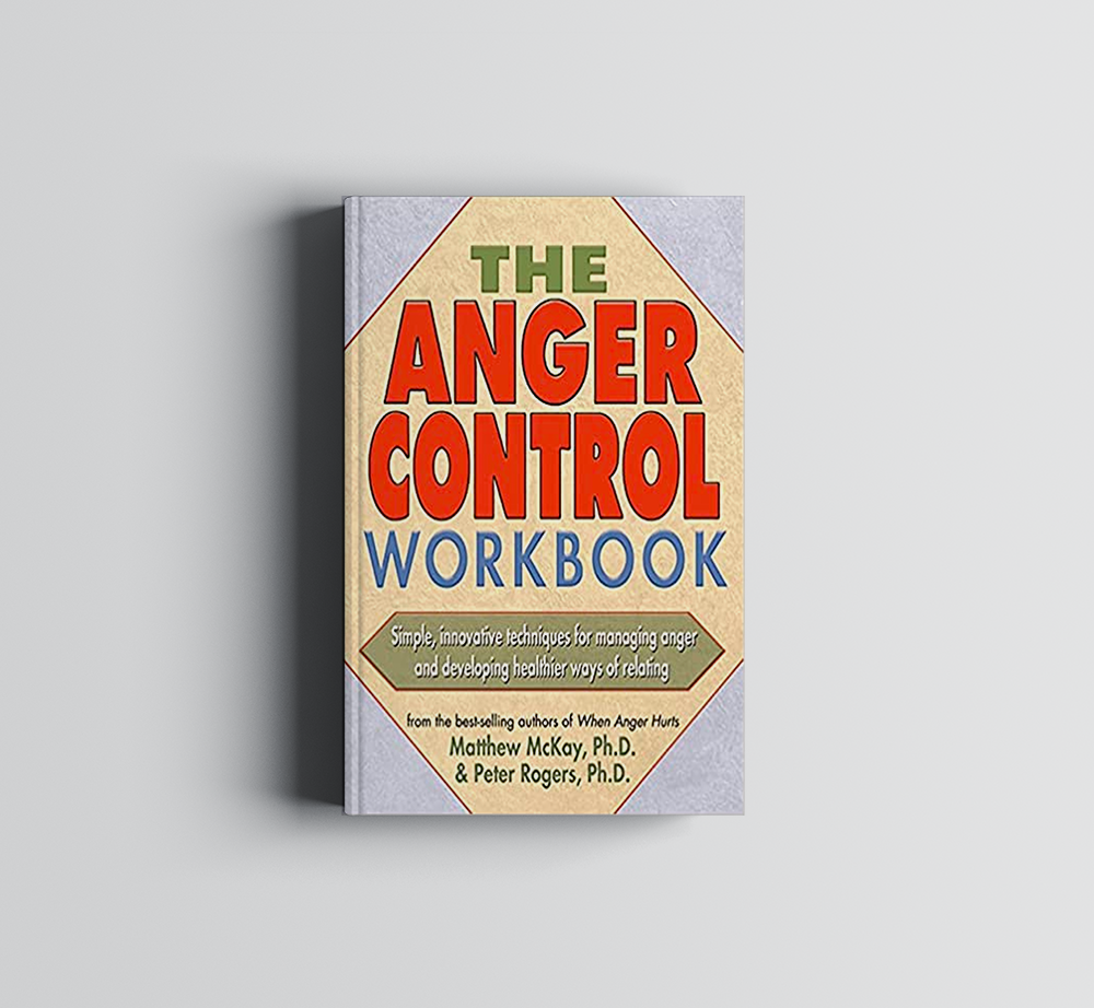 A book titled The Anger Control Workbook is sitting on a table.