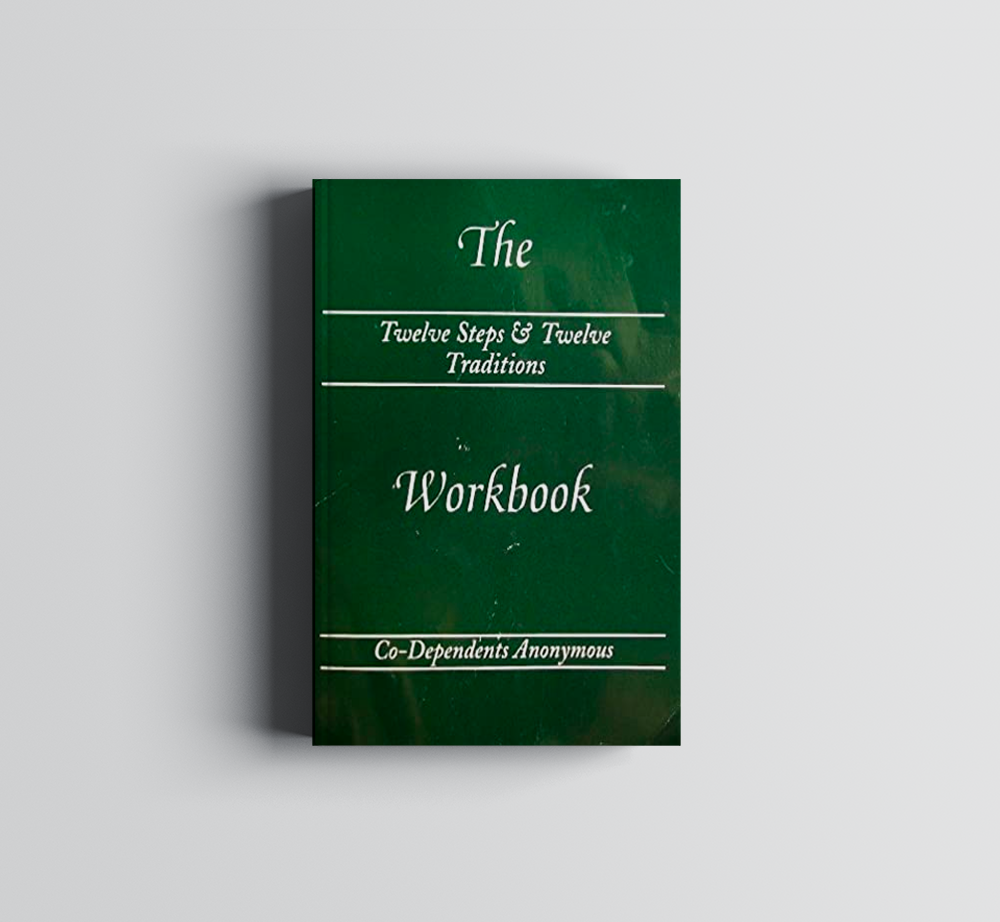 A green book titled The Twelve Steps & Twelve Traditions Workbook by Co-Dependents Anonymous