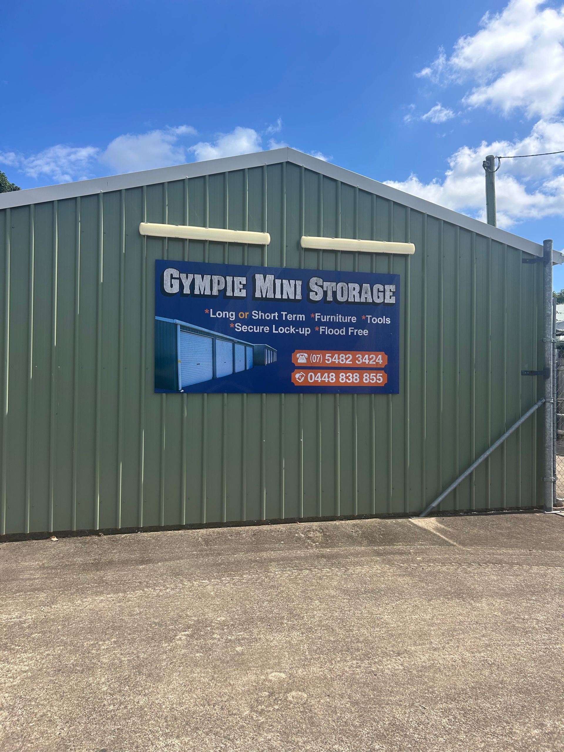 Green storage building with a sign that reads
