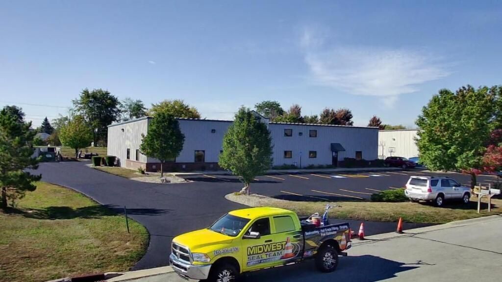 Sealcoat application on parking lot in Fort Wayne, IN. You can see a commercial l parking lot in Fort Wayne, IN, receiving a fresh application of sealcoat to protect it from heavy use.
