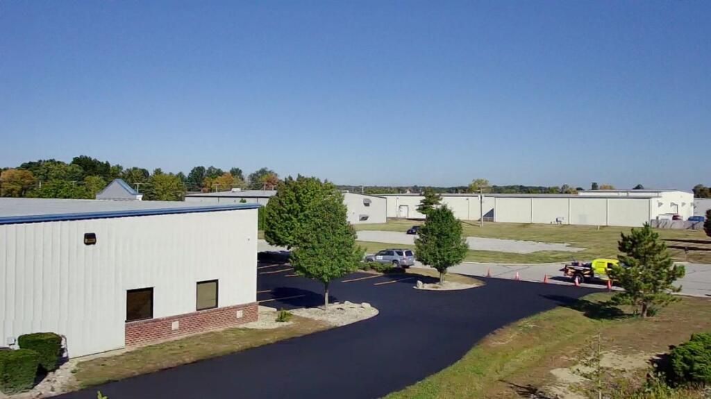 Sealcoat application on a commercial property in Fort Wayne, IN, during the fall season.
