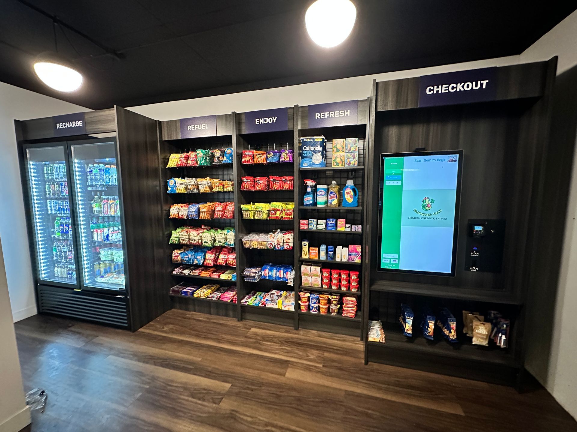 Convenience store snack wall with chips, drinks, and a touchscreen kiosk under bright lights