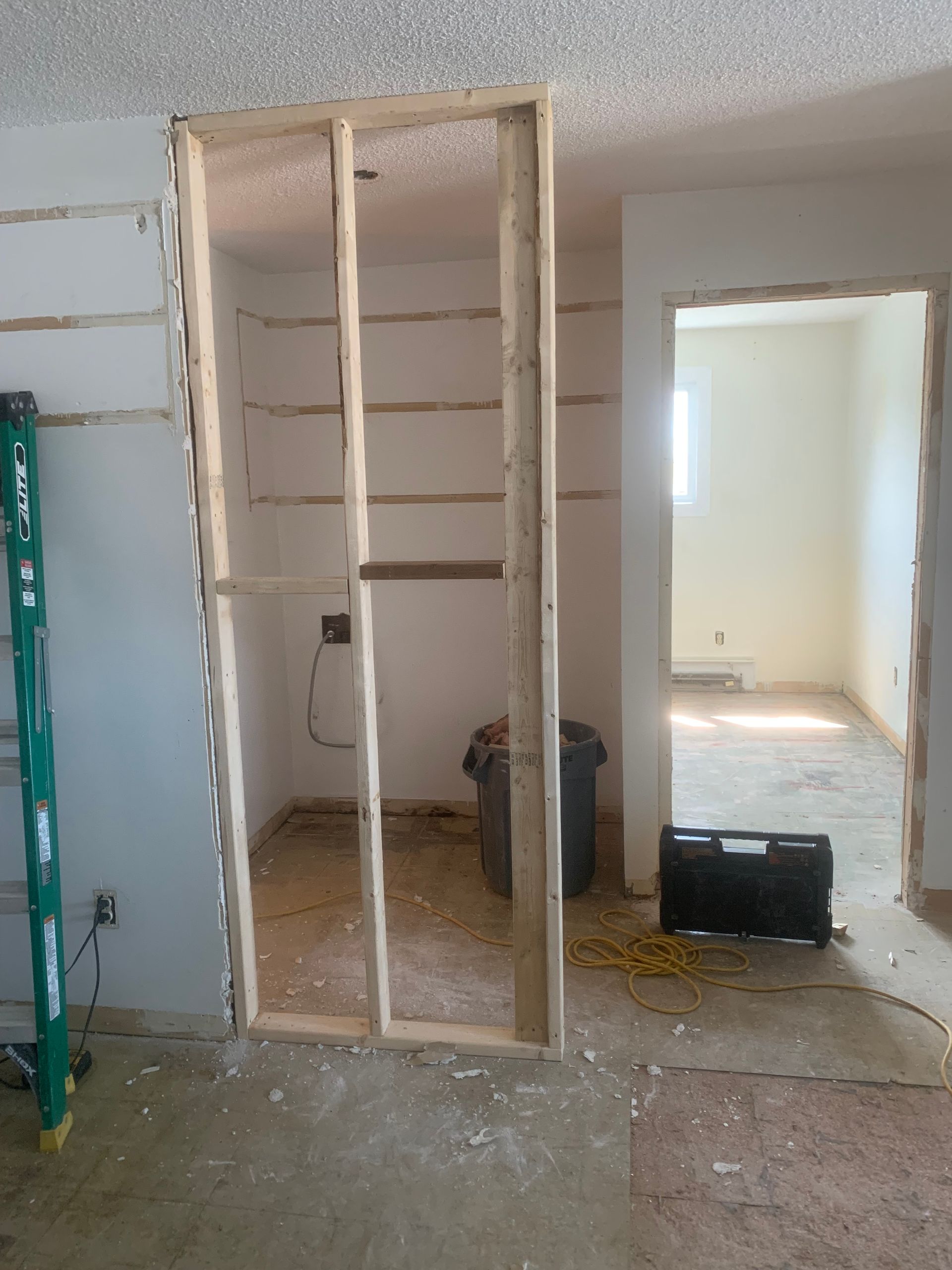 Travaux intérieurs : ossature en bois pour la construction d’un mur ou d’une étagère ; pièce avec murs et cadre de porte non finis.
