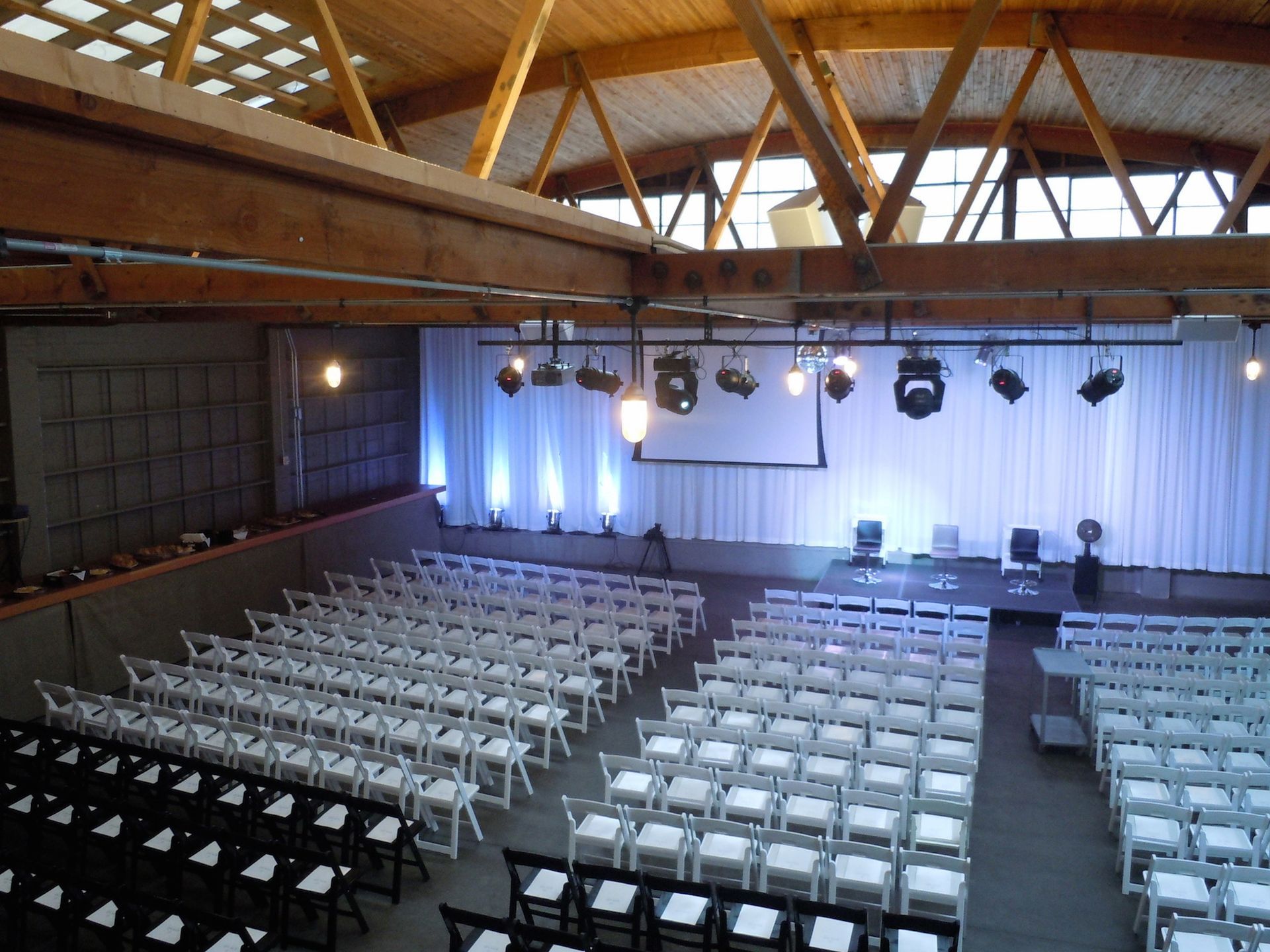 Rows of white chairs are lined up in a large room
