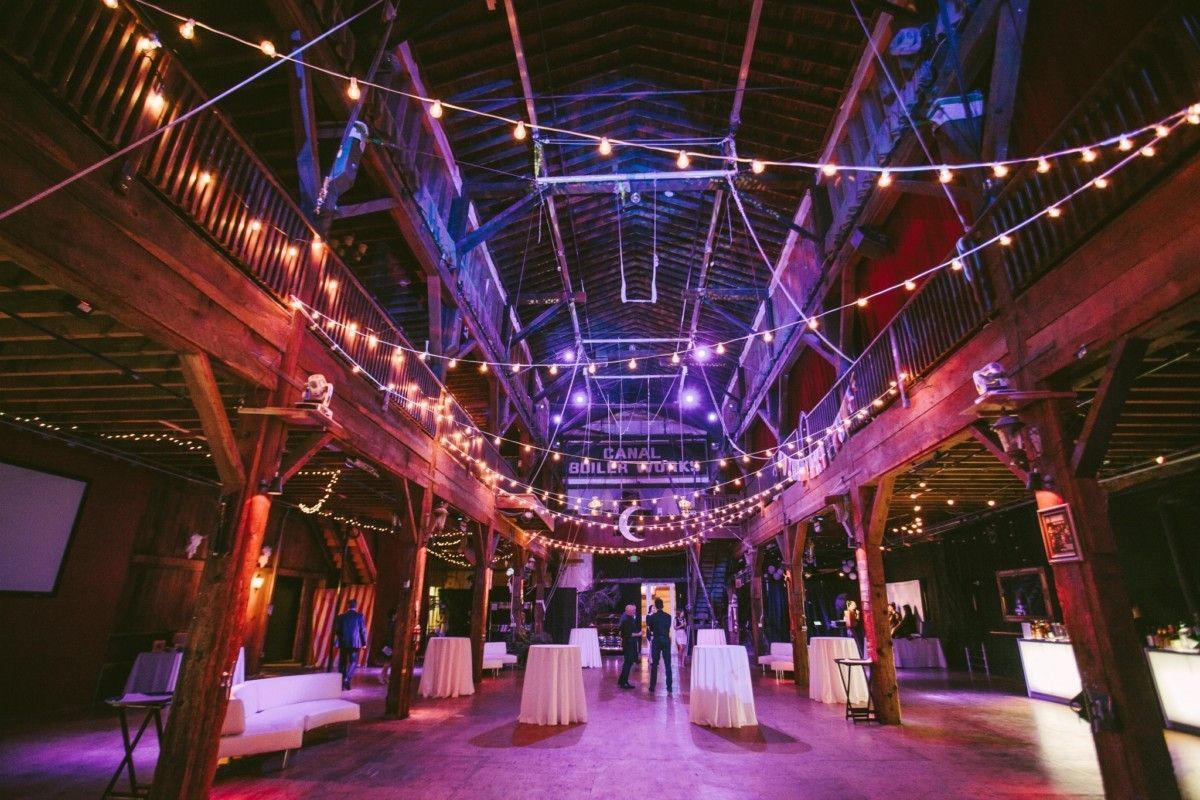 A large room with tables and lights hanging from the ceiling.