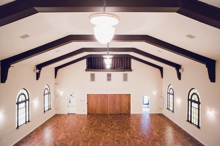 A large empty room with a chandelier hanging from the ceiling