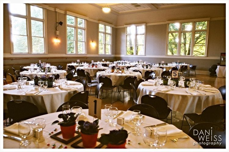 A large room with tables and chairs set up for a wedding reception.