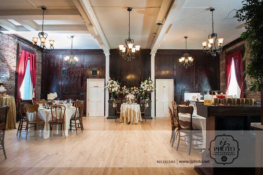 A large room with tables and chairs set up for a wedding reception.