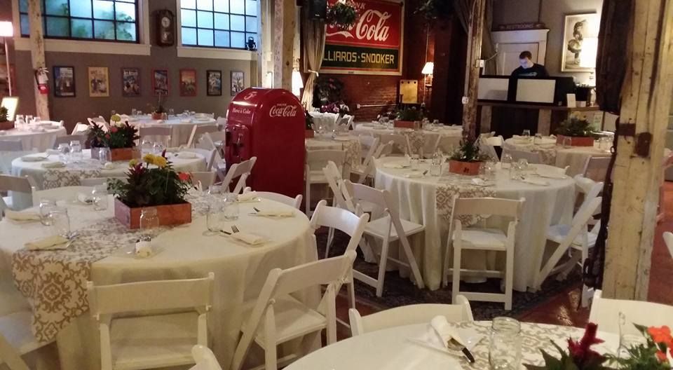 A room filled with tables and chairs with a coca cola sign in the background.