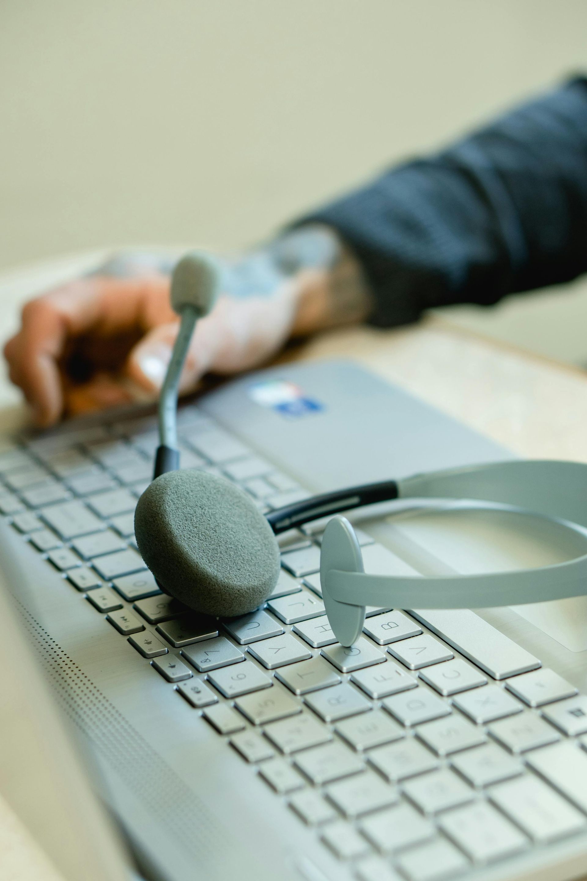 A person wearing headphones is typing on a keyboard