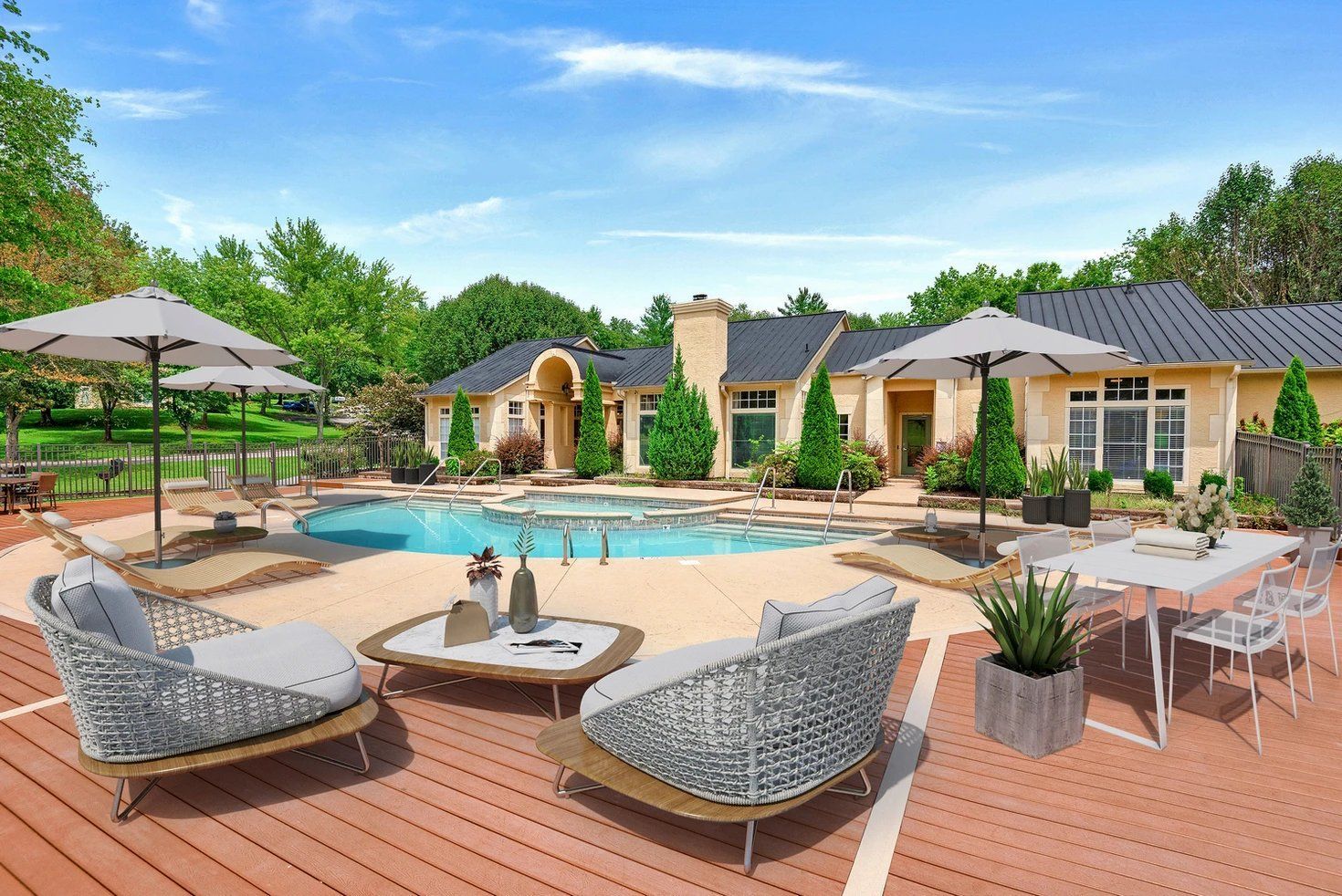 Sunny resort-style patio with pool, lounge chairs, umbrellas, and landscaped cottages at Steeplechase Apartments for Rent in Knoxville, TN