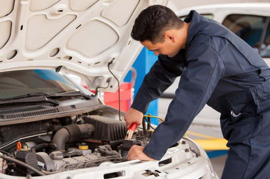 A Man Is Working Under The Hood Of A Car — Goulburn Automotive Centre In Goulburn, NSW
