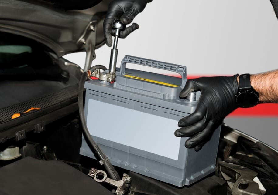 A Person Is Fixing A Car Battery With A Wrench — Goulburn Automotive Centre In Goulburn, NSW