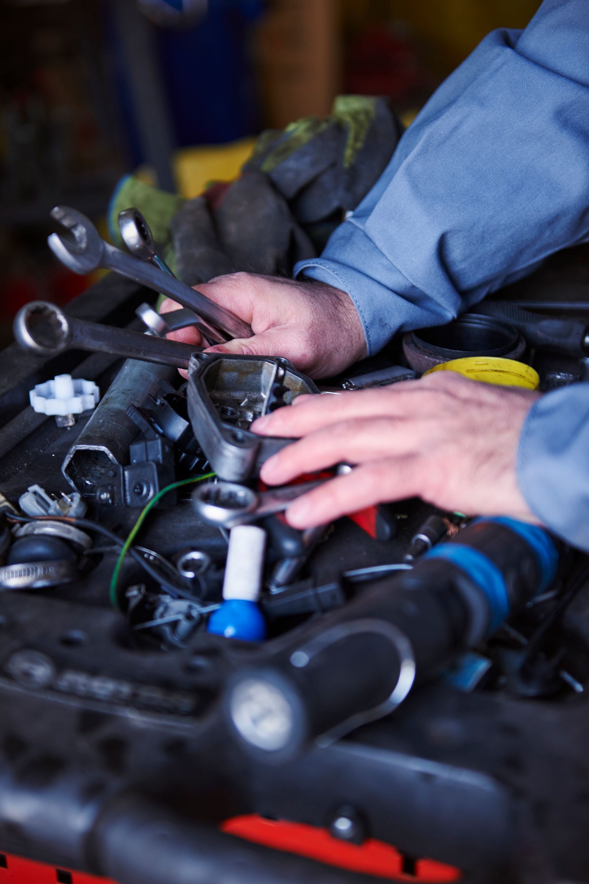 A Man Is Working On A Car Engine With A Wrench — Goulburn Automotive Centre In Goulburn, NSW