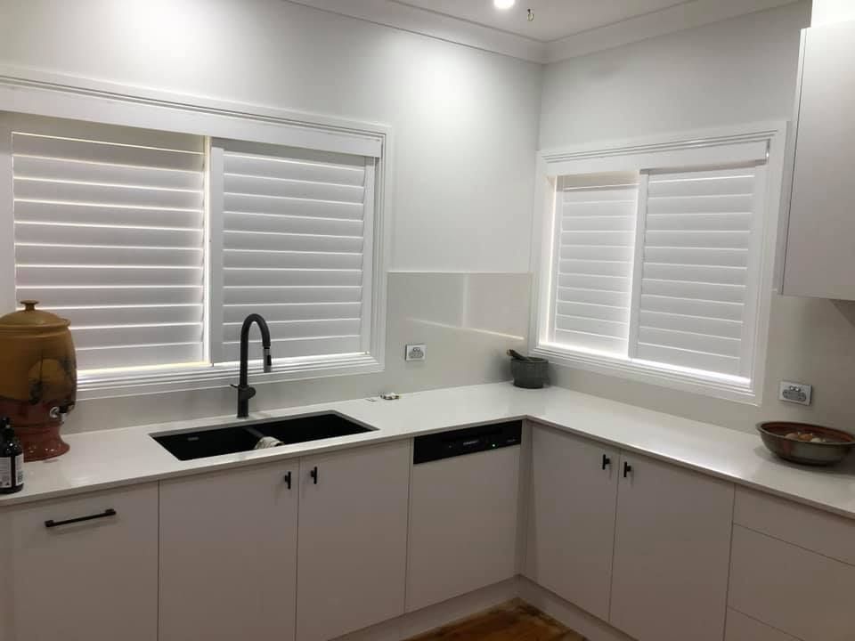 Bright White Kitchen with Cabinets and Two Windows with Blinds — Tamworth Blinds & Awnings in Walcha, NSW