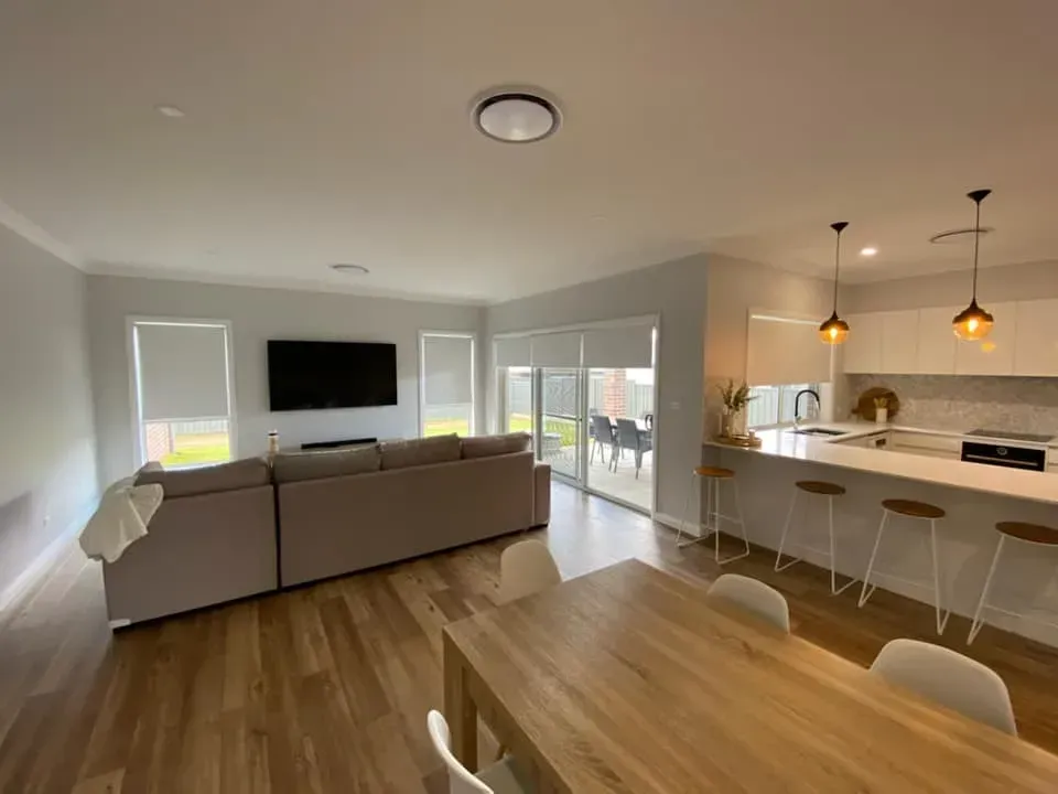 Open-Plan Living Room and Kitchen with Gray Sofa — Tamworth Blinds & Awnings in Tamworth, NSW