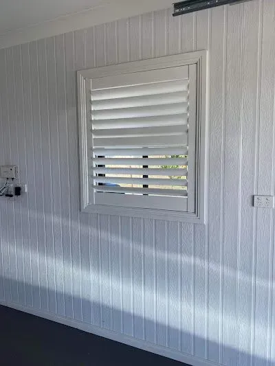 White Wall with A Small Window Covered by White Shutters — Tamworth Blinds & Awnings in Gunnedah, NSW